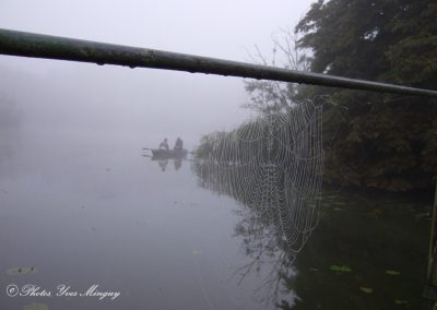 Pêcheurs en barque dans la brume sur le marais